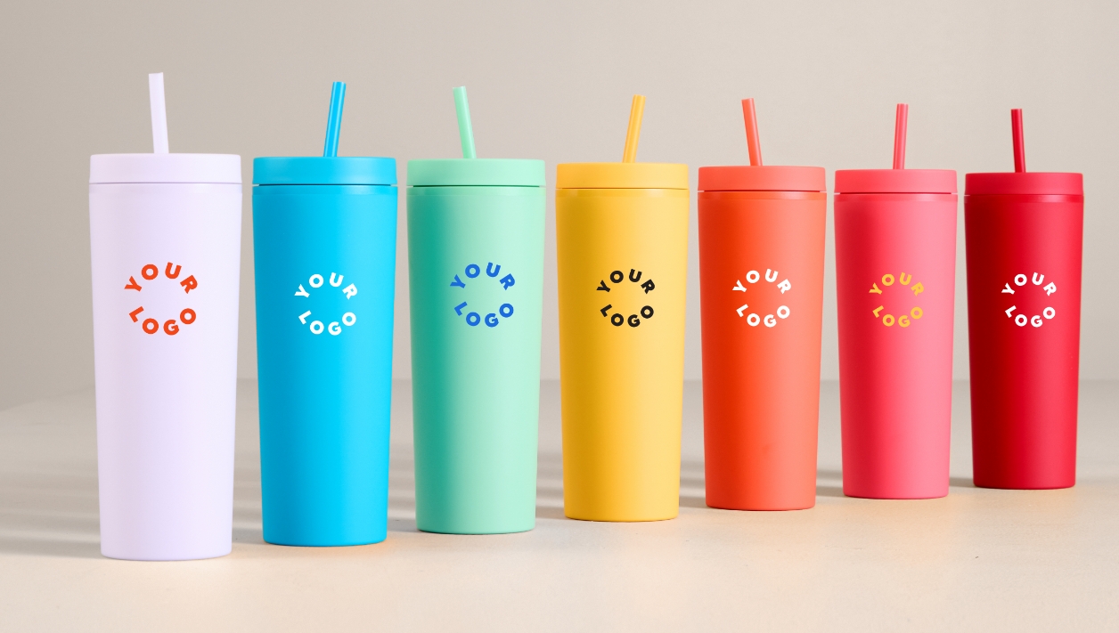 Many straw tumblers, set up in rainbow color order on a table, all are branded with Your Logo to show personalization for your businesses
