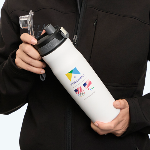 A person in a Team USA jacket holding a co-branded water tumbler with the Pennymac, the USA Olympics, and the USA Paralympics logos along with the words Proud Supporter