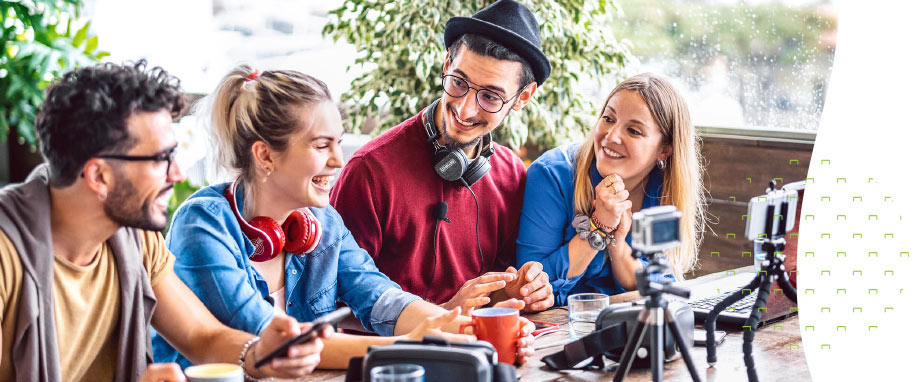 Four Millennials Sitting at a Table Smiling