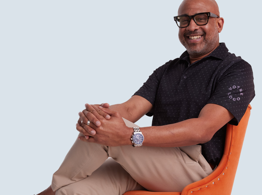 Smiling man wearing a black patterned custom logo polo shirt. highlighting the polo section of branded apparel