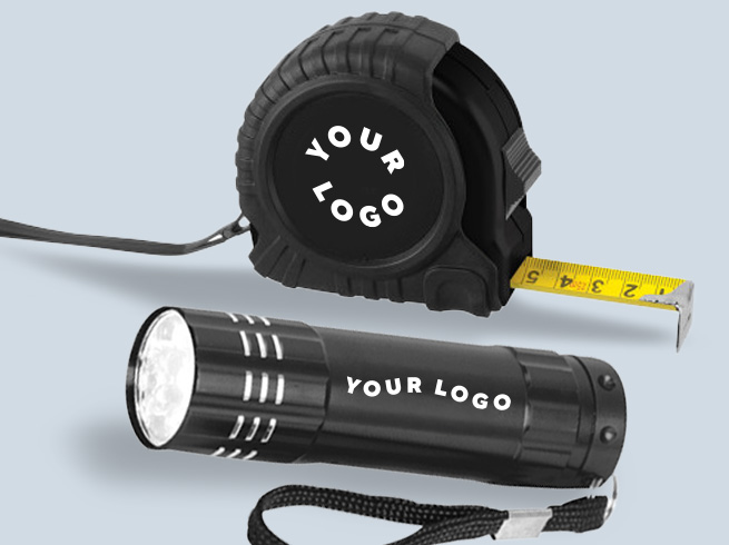 Flat lay of jumper cables, warning sign, flashlight, and black-blue branded bag with YOUR LOGO on it – represents Auto and Tools products.