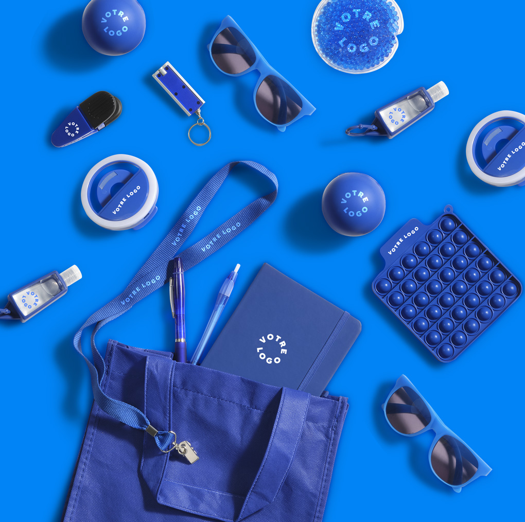 Flat lay of blue branded lanyard, pen, stress ball, pop-it toy, and drawstring bag — labeled Events and Tradeshow for promo uses