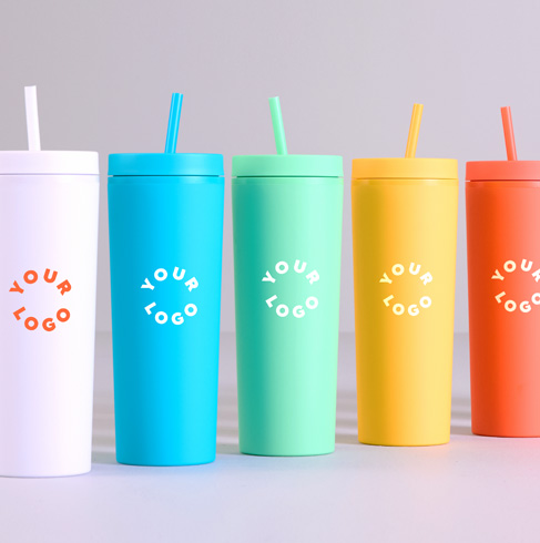 Two coworkers exchange branded mugs beside an orange gift bag labeled Corporate Gifts — showcasing custom gift options.