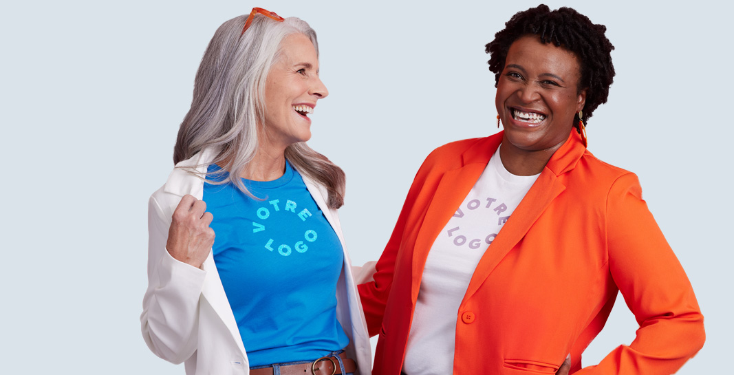Two smiling women in branded shirts and jackets. part of the women’s custom apparel category.